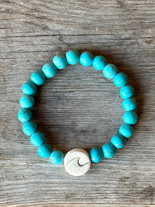 Studio Meraki bacelet with turqoise chrystal pearls and a raw ceramic pearl with a wave.