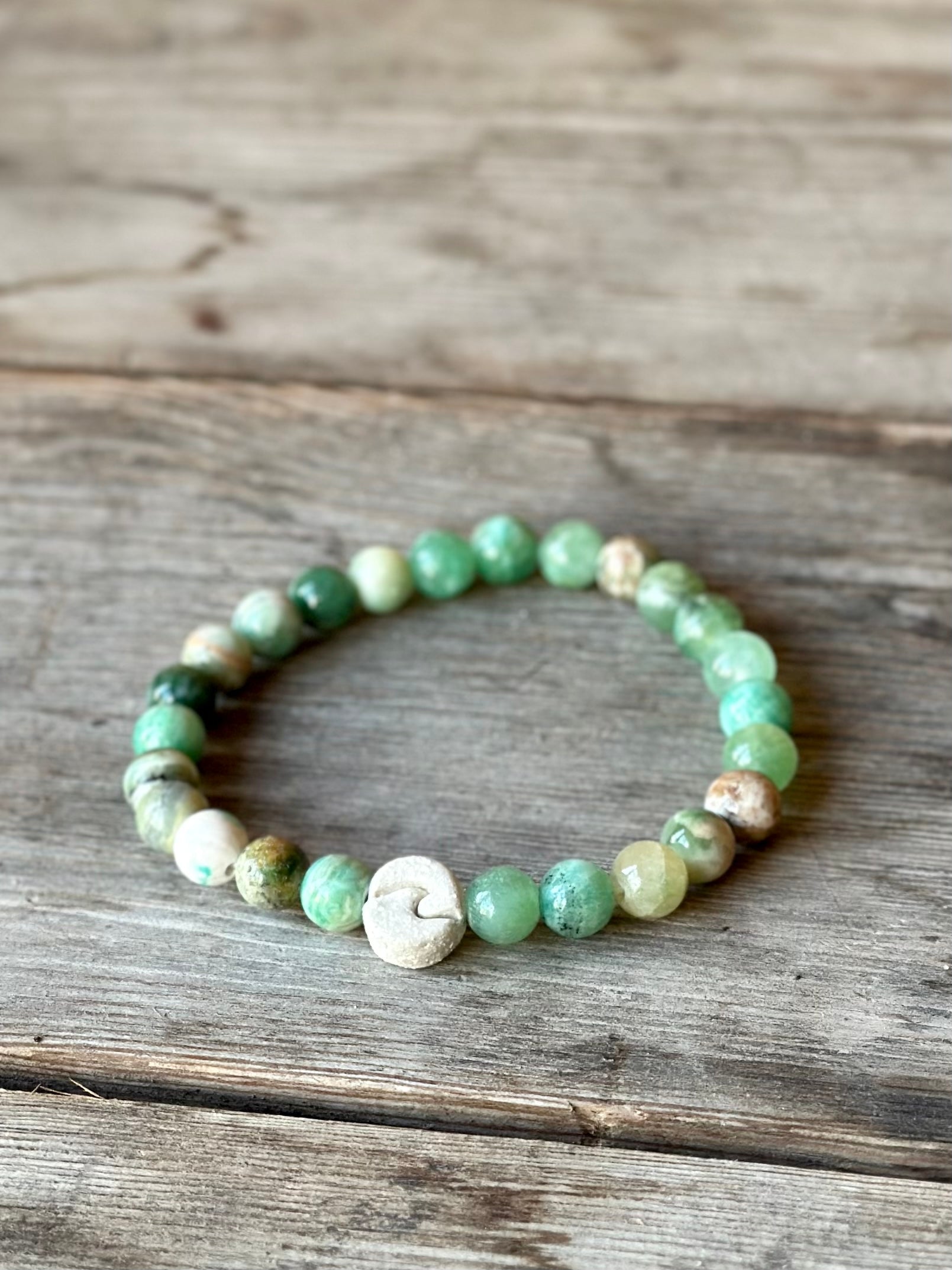 Studio Meraki bacelet with calcite chrystal pearls and a raw ceramic pearl with a wave.