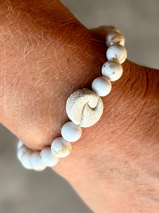 Studio Meraki bacelet with howlite chrystal pearls and a raw ceramic pearl with a wave.