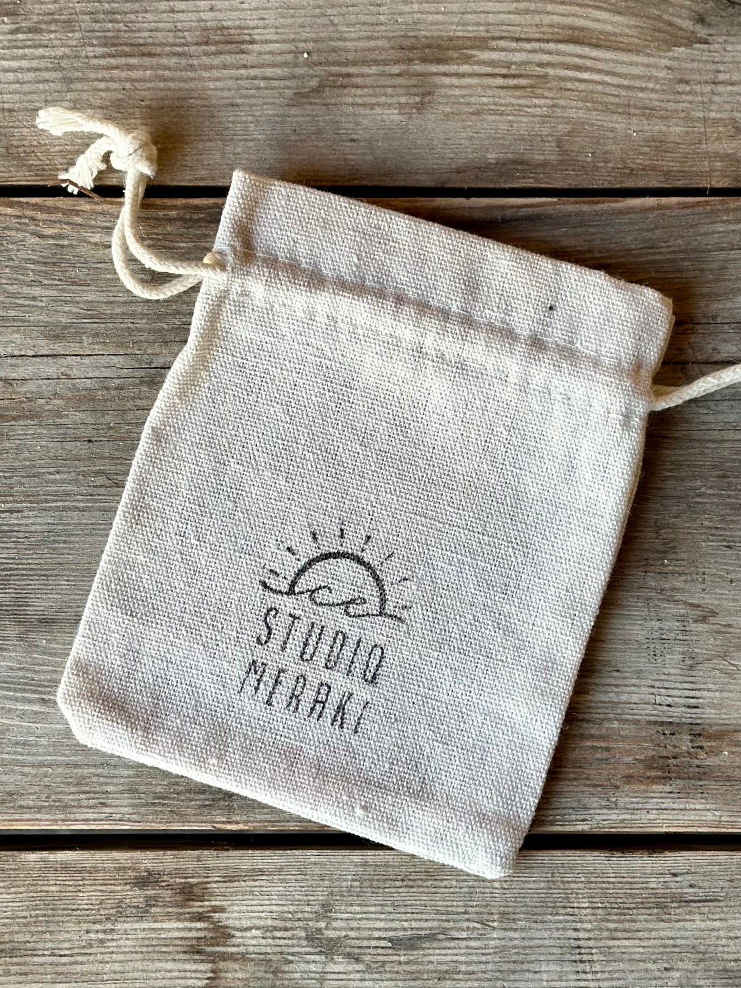 Studio Meraki gift bag for bracelets and necklaces, linnen texture with printed logo.