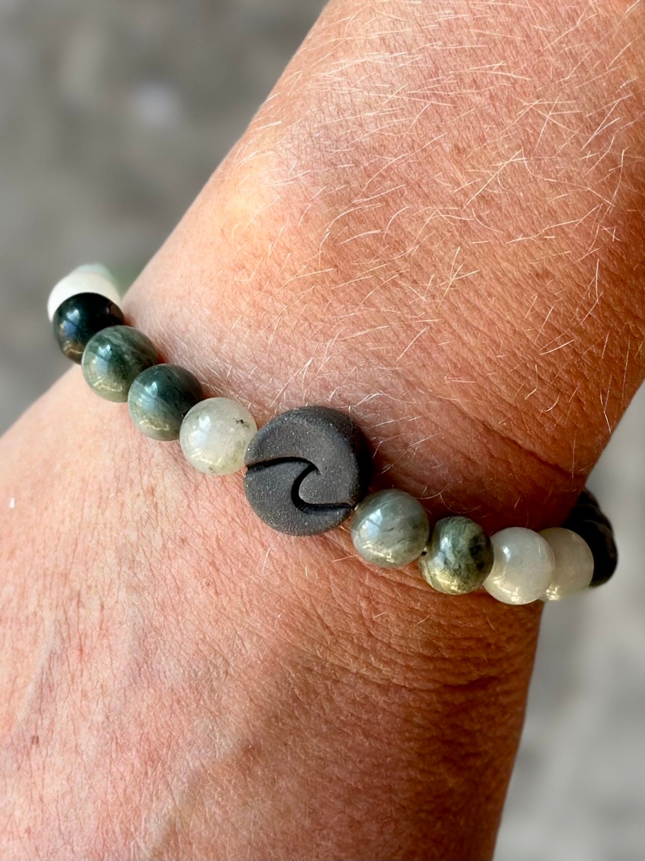 Studio Meraki bacelet with agate chrystal pearls and a raw ceramic pearl with a wave.