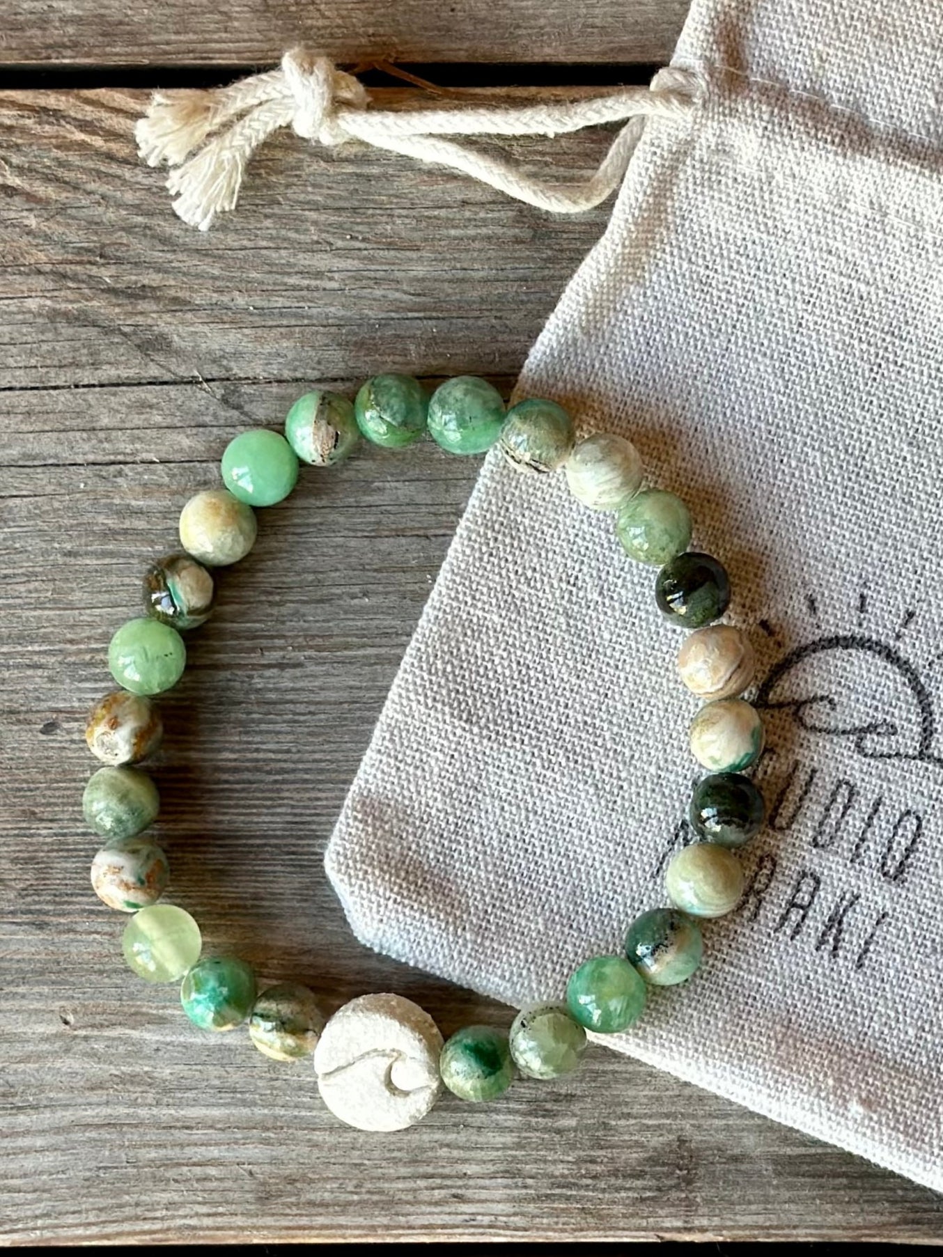 Studio Meraki bacelet with calcite chrystal pearls and a raw ceramic pearl with a wave.