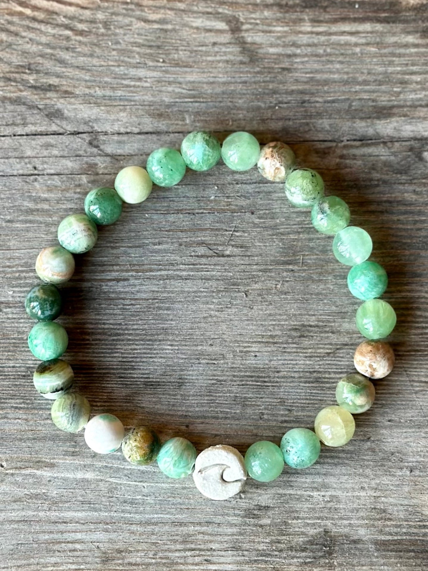 Studio Meraki bacelet with calcite chrystal pearls and a raw ceramic pearl with a wave.