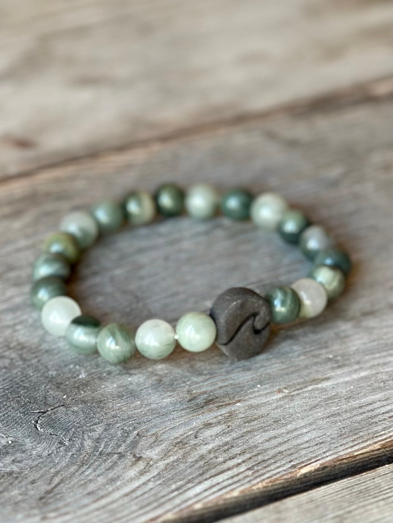 Studio Meraki bacelet with agate chrystal pearls and a raw ceramic pearl with a wave.