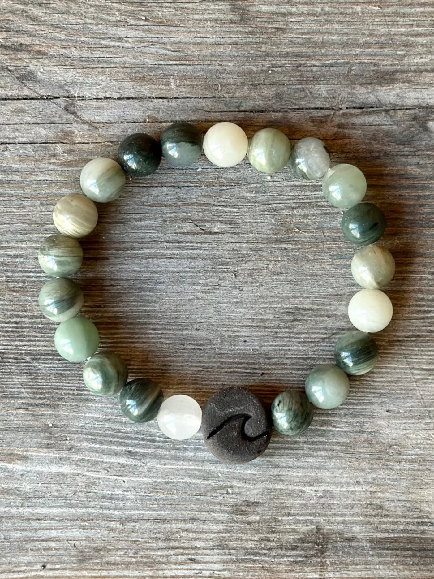 Studio Meraki bacelet with agate chrystal pearls and a raw ceramic pearl with a wave.