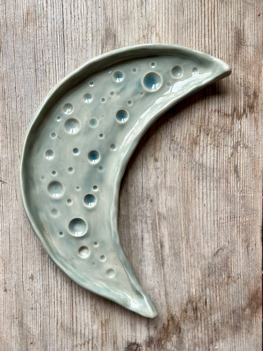 Moon shaped decorative ceramic tray with dark grey blue glaze.