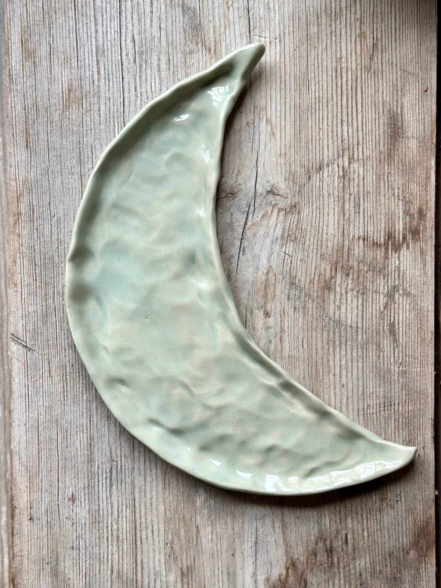 Moon shaped decorative tray in light aqua green glaze.