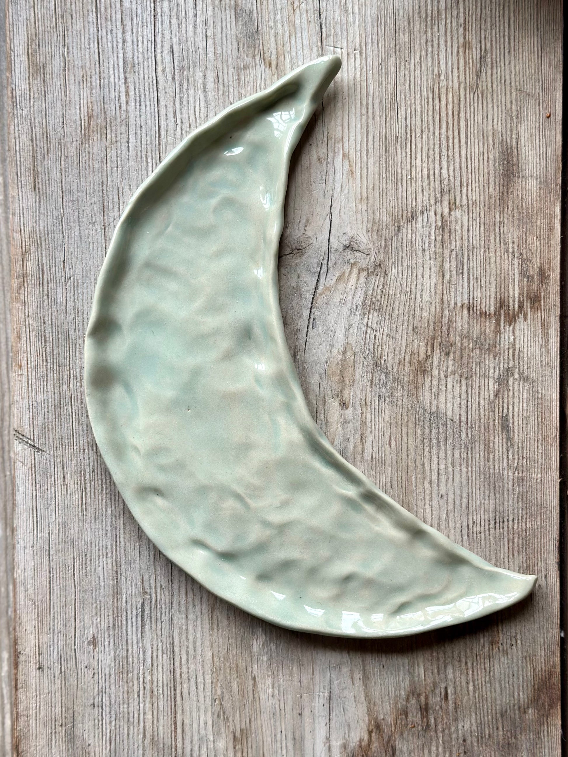 Moon shaped decorative tray in light aqua green glaze.