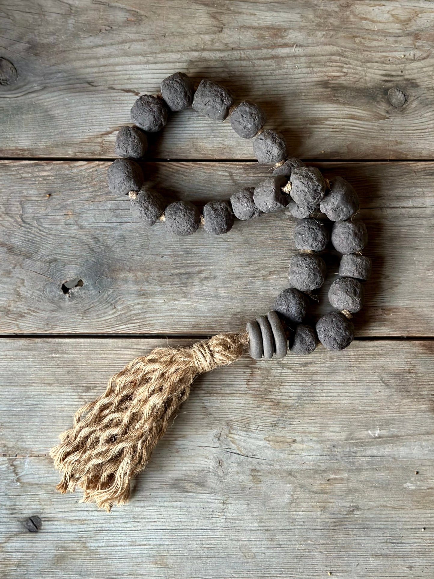 Studio Meraki Decorative ceramic bead garland with black beads and hemp tassle