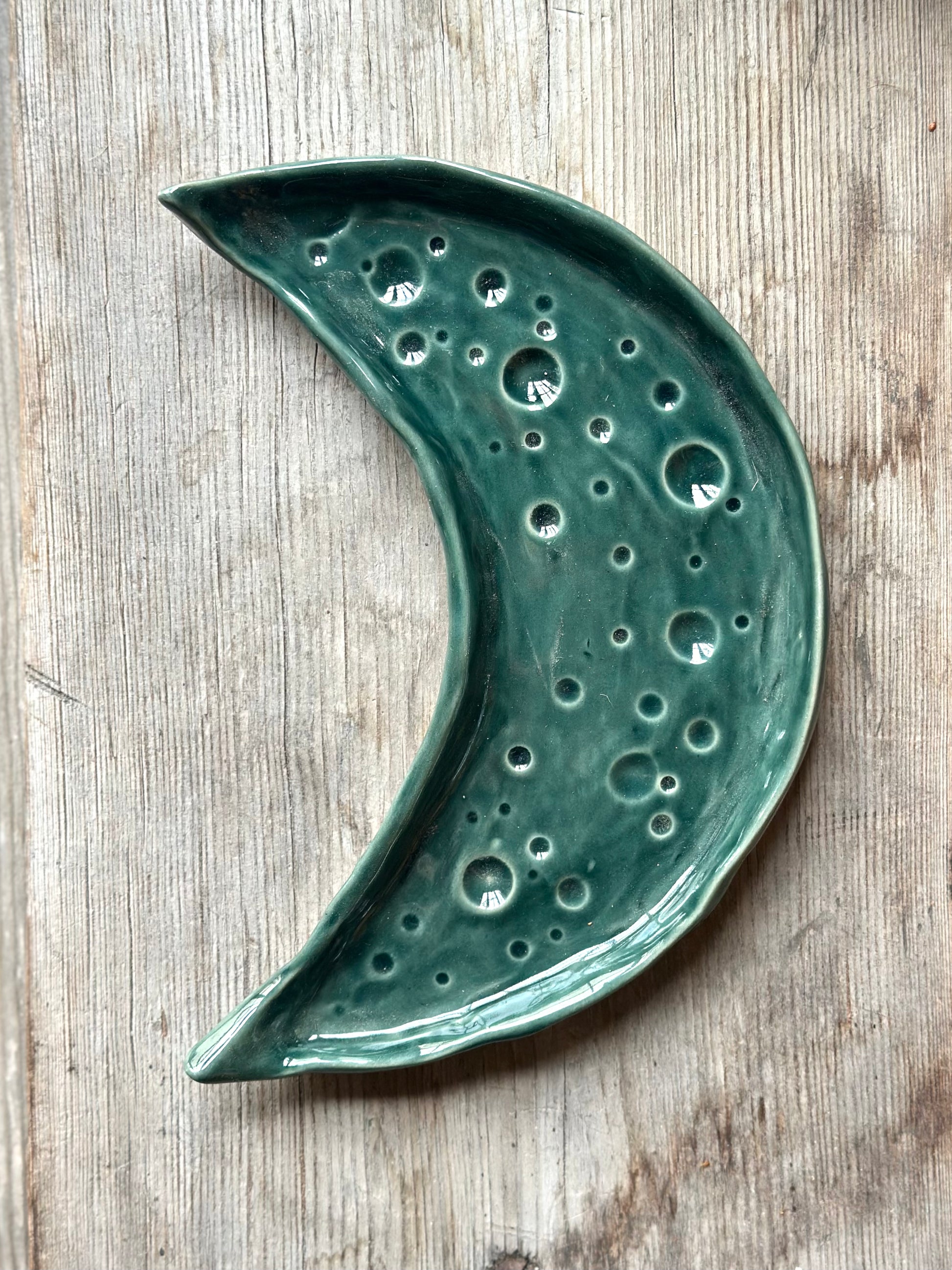 Moon shaped decorative ceramic tray with dark green glaze.