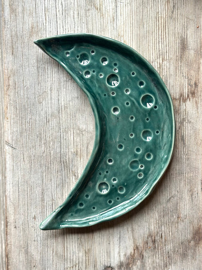 Moon shaped decorative ceramic tray with dark green glaze.