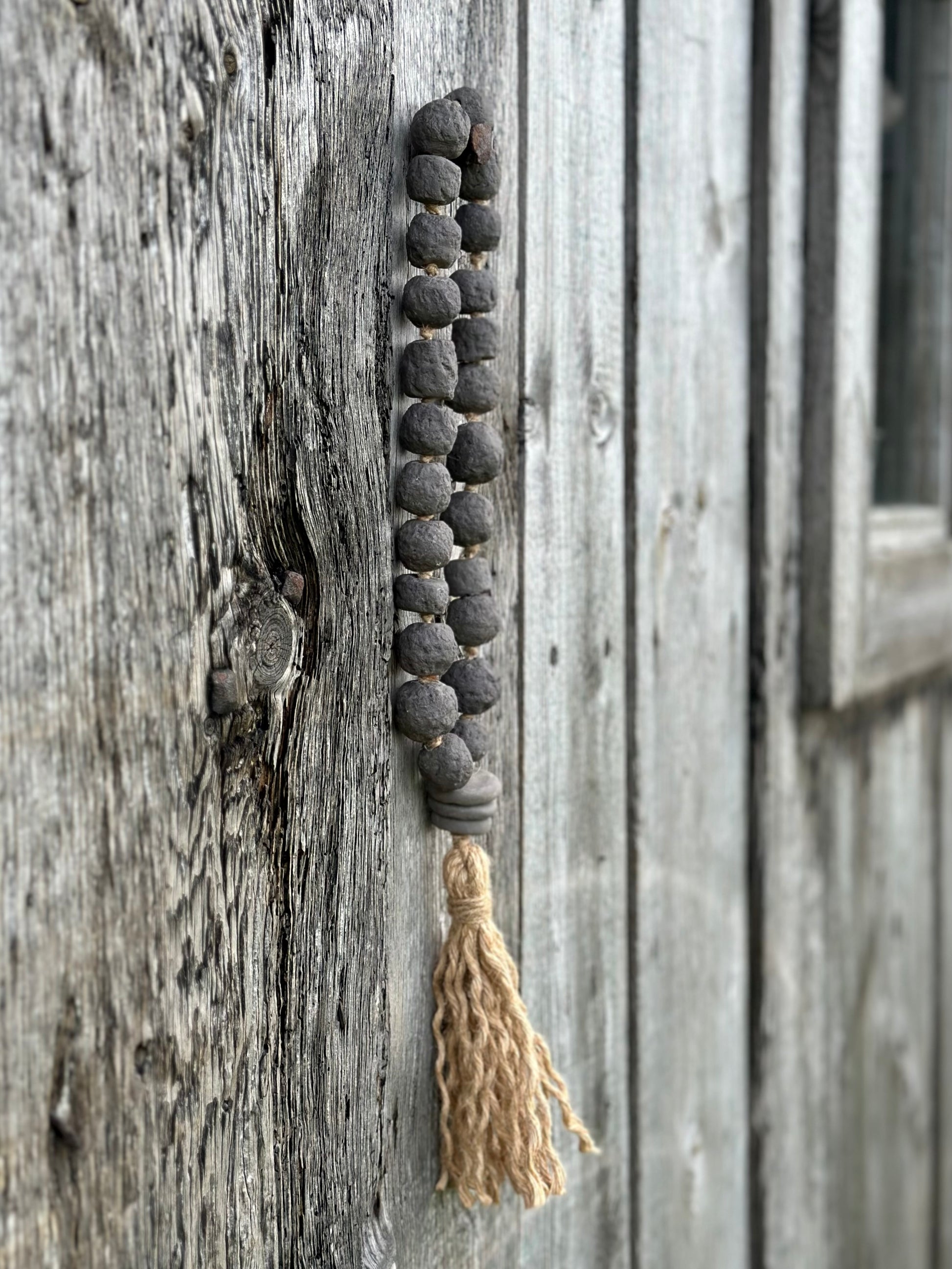 Studio Meraki Decorative ceramic bead garland with black beads and hemp tassle