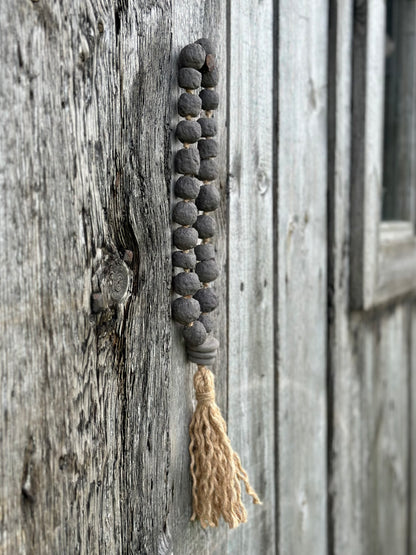 Studio Meraki Decorative ceramic bead garland with black beads and hemp tassle