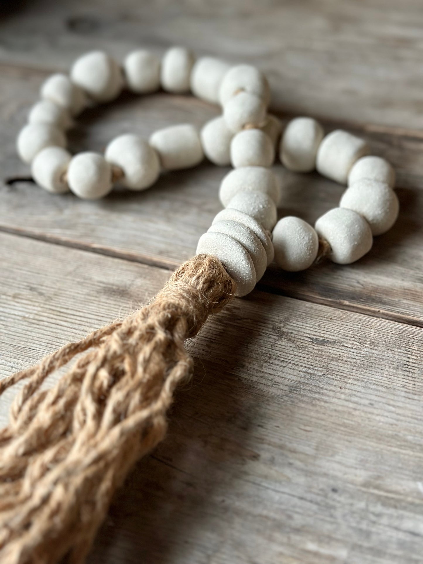 Studio Meraki Decorative ceramic bead garland with black beads and hemp tassle