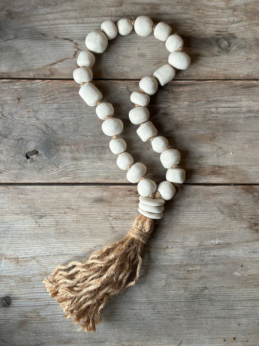 Studio Meraki Decorative ceramic bead garland with black beads and hemp tassle