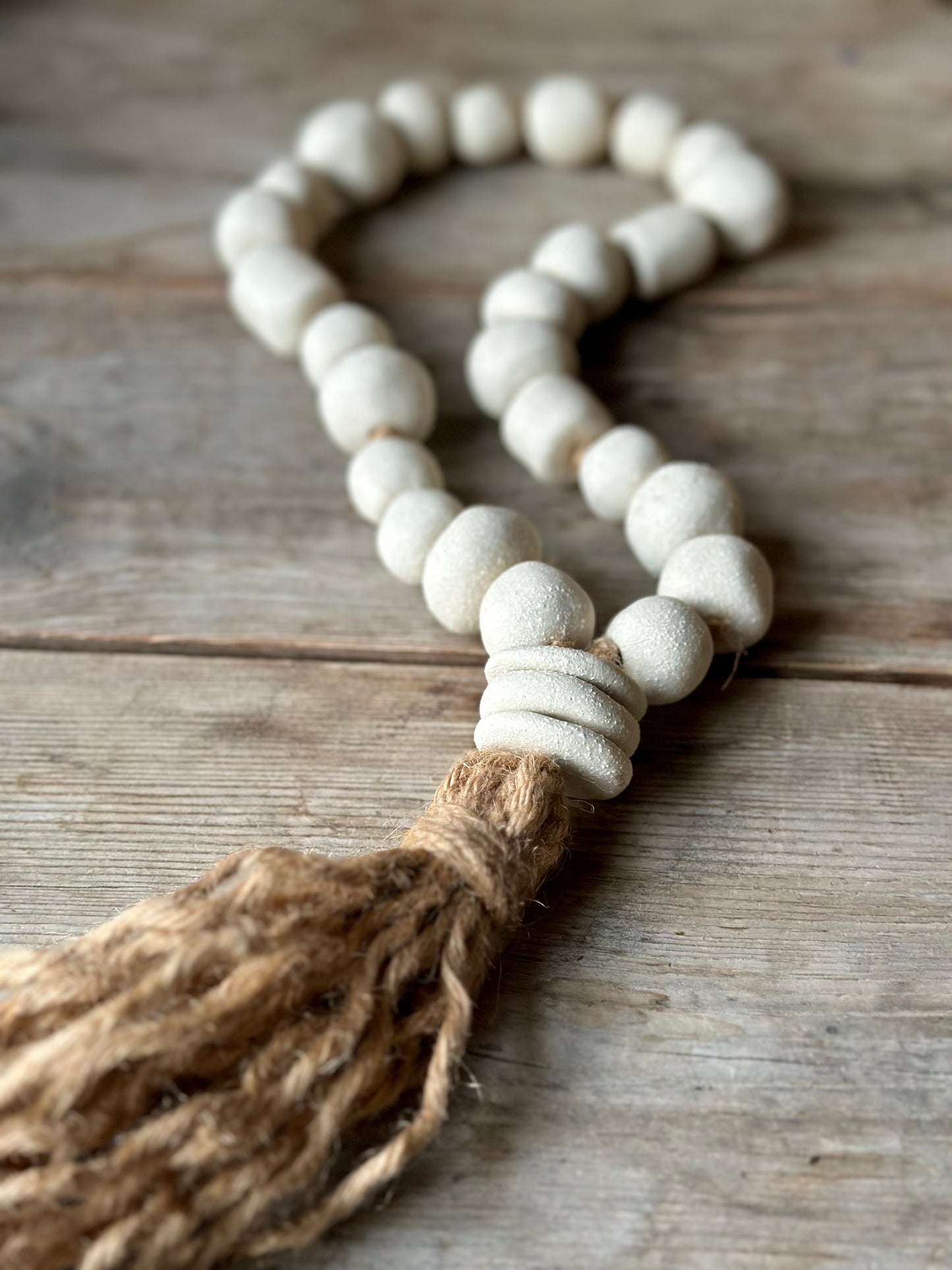 Studio Meraki Decorative ceramic bead garland with black beads and hemp tassle