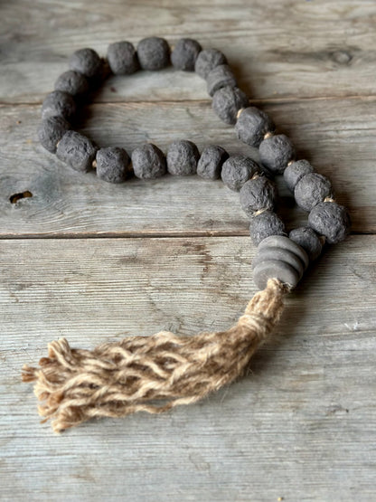 Studio Meraki Decorative ceramic bead garland with black beads and hemp tassle