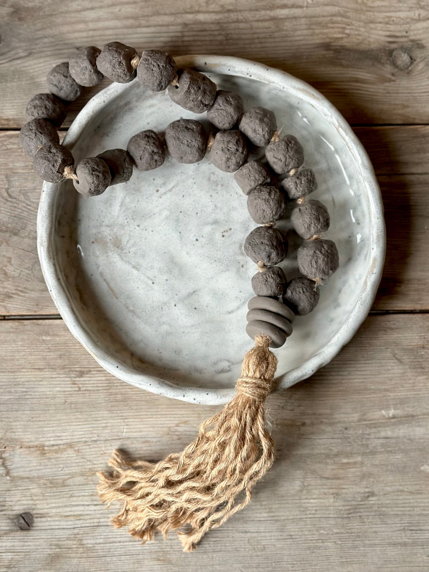 Studio Meraki Decorative ceramic bead garland with black beads and hemp tassle