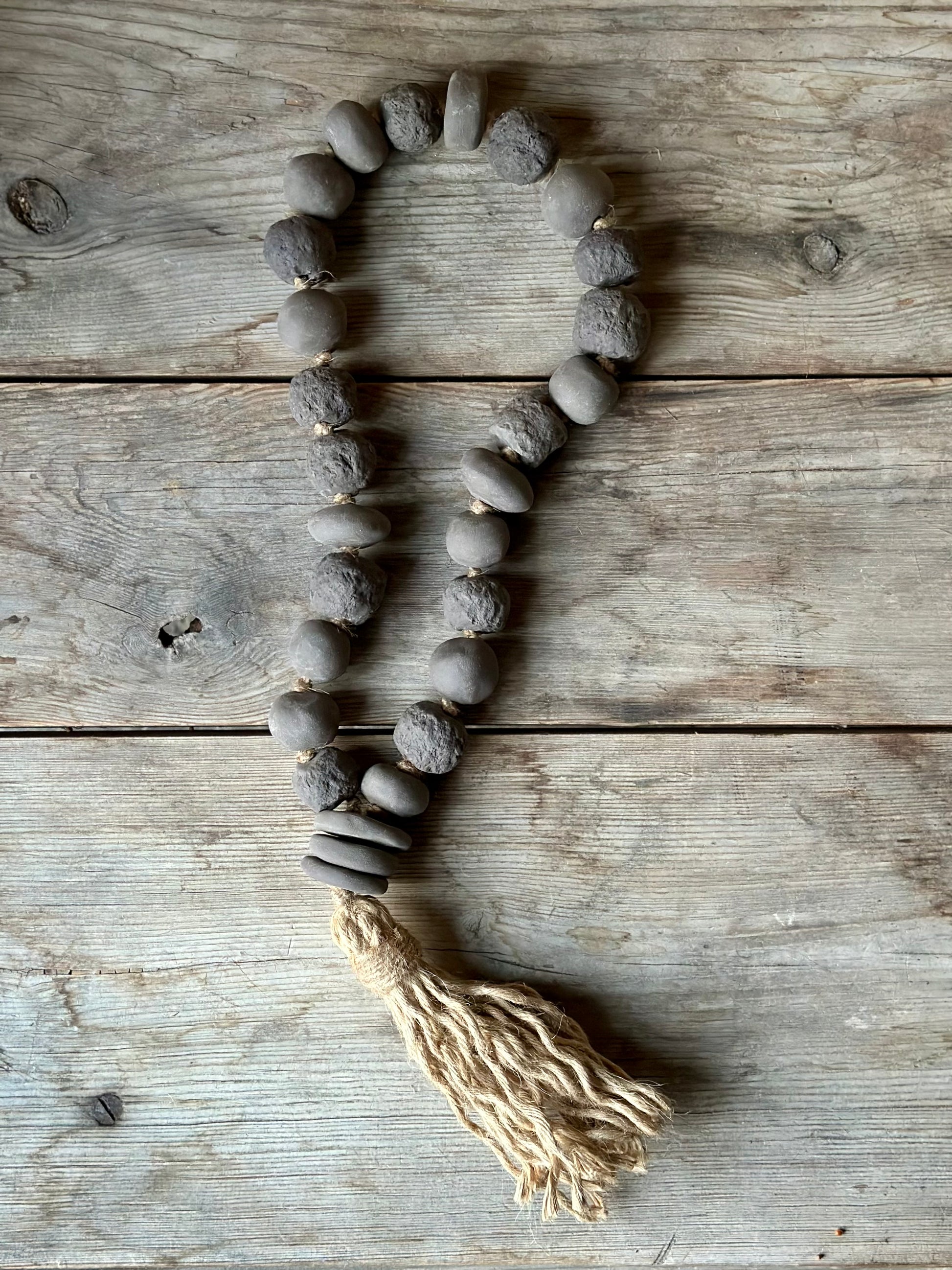 Studio Meraki Decorative ceramic bead garland with black beads and hemp tassle