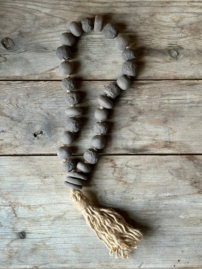 Studio Meraki Decorative ceramic bead garland with black beads and hemp tassle