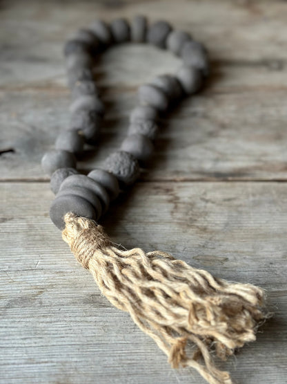 Studio Meraki Decorative ceramic bead garland with black beads and hemp tassle