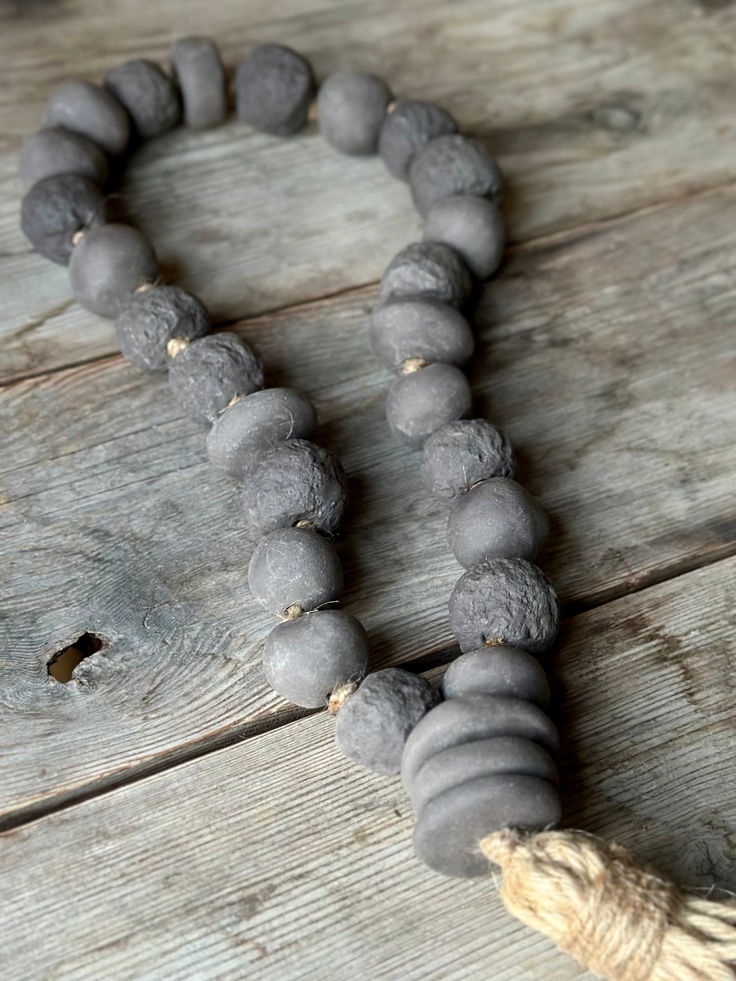 Studio Meraki Decorative ceramic bead garland with black beads and hemp tassle