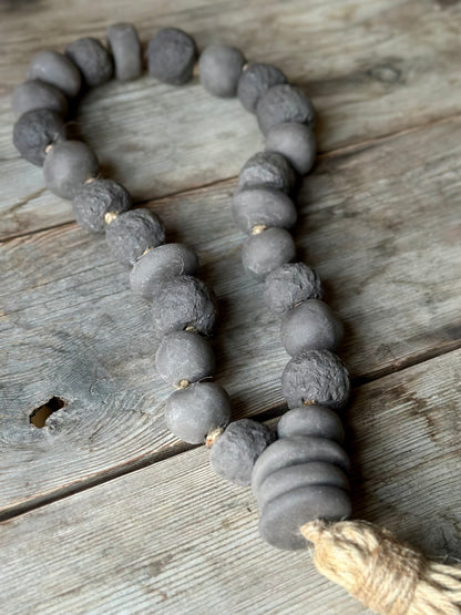 Studio Meraki Decorative ceramic bead garland with black beads and hemp tassle